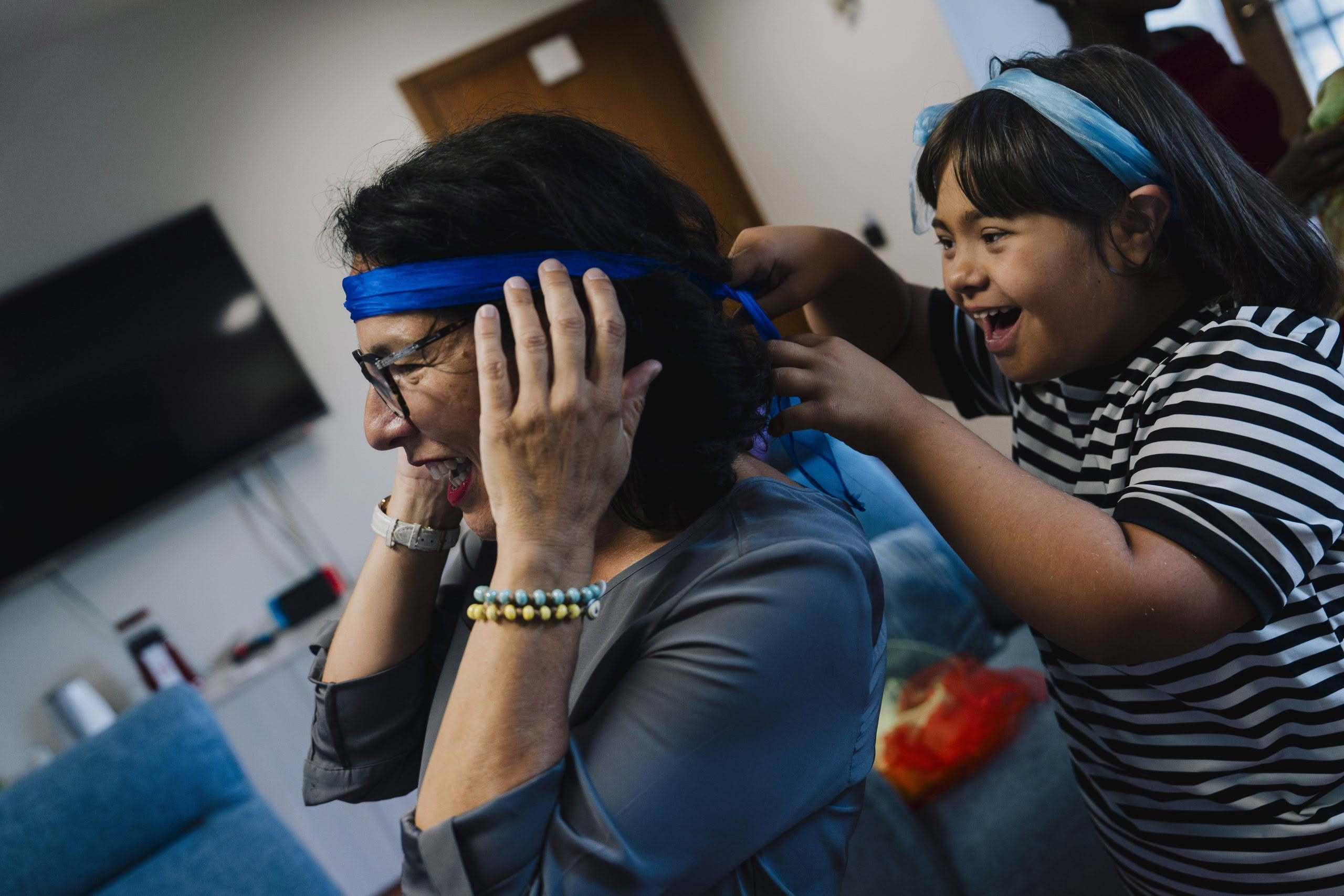 A girl tying a headband around her mum