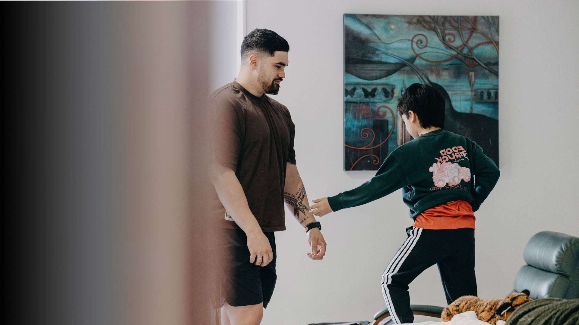 Dad helping son put on sweater