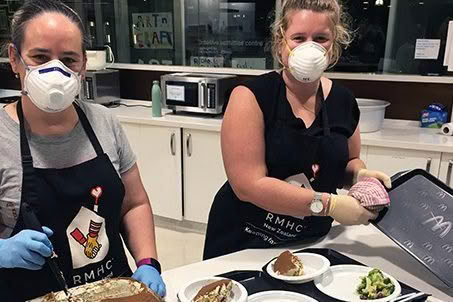 Volunteers cooking in kitchen